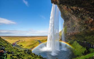 A rainbow arching in front of Seljalandsfoss Waterfall on Iceland's South Coast.