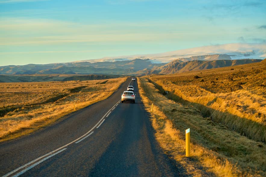 A car driving the Ring Road through golden autumn landscapes in North Iceland.