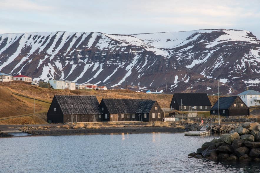 Black timber houses by the harbor in Hofsos Village in North Iceland in autumn.