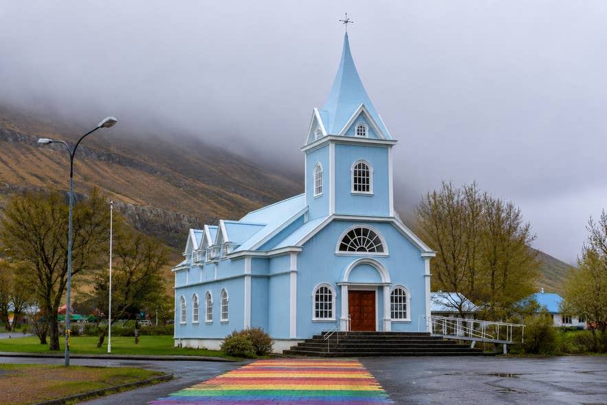 Seydisfjardarkirkja Church with its famous rainbow street in Seydisfjordur in East Iceland. 