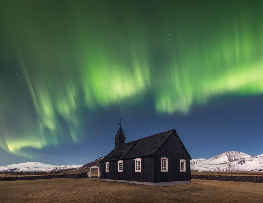 The northern lights shine above Budakirkja Church on the Snaefellsnes Peninsula in Iceland.