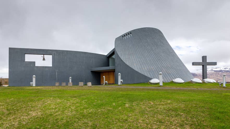 Blönduóskirkja modern concrete church in Blönduós, Skagi Peninsula, Iceland, with curved roof and cross.