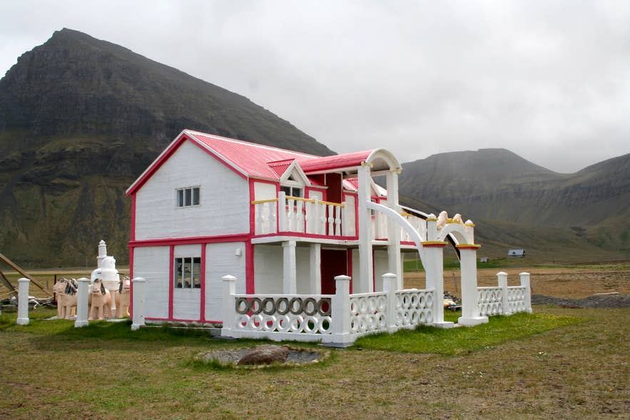 Samuel Jónsson Art Farm in Selárdalur Valley, Iceland, with sculptures and buildings set against mountains.