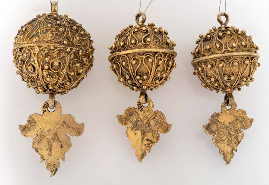 Faldbúningur sleeve silverwork with ornate gilt filigree balls and dangling leaf-shaped pendants. Faldbúningur sleeve silverwork with ornate gilt filigree balls and dangling leaf-shaped pendants.