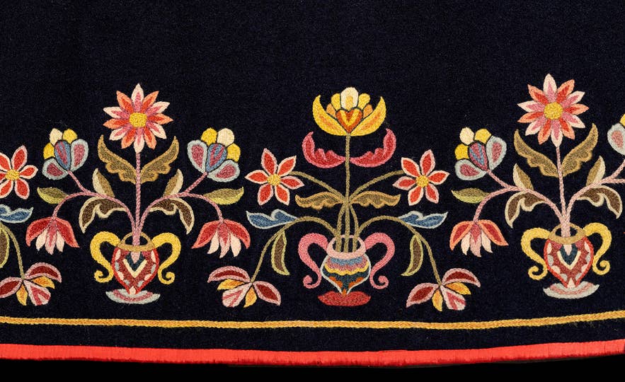 Close-up of colorful floral embroidery on a traditional Icelandic faldbúningur from the National Museum of Iceland.