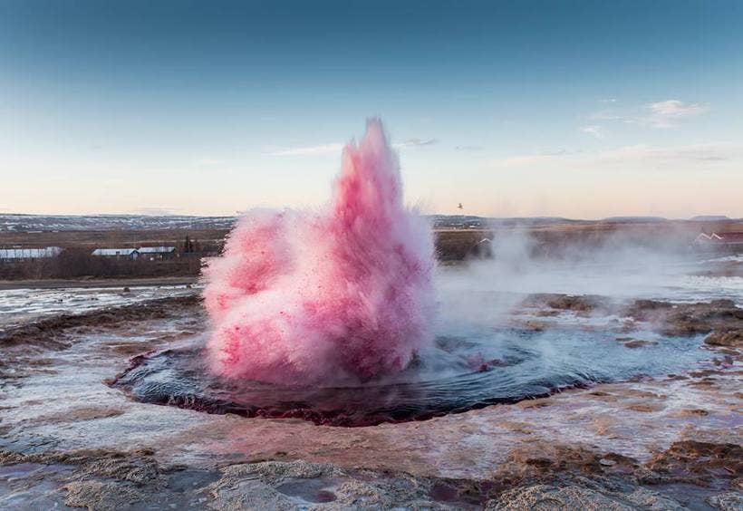 Strokkur geyser erupts bright pink after red dye was poured into its vent in a 2015 art stunt.