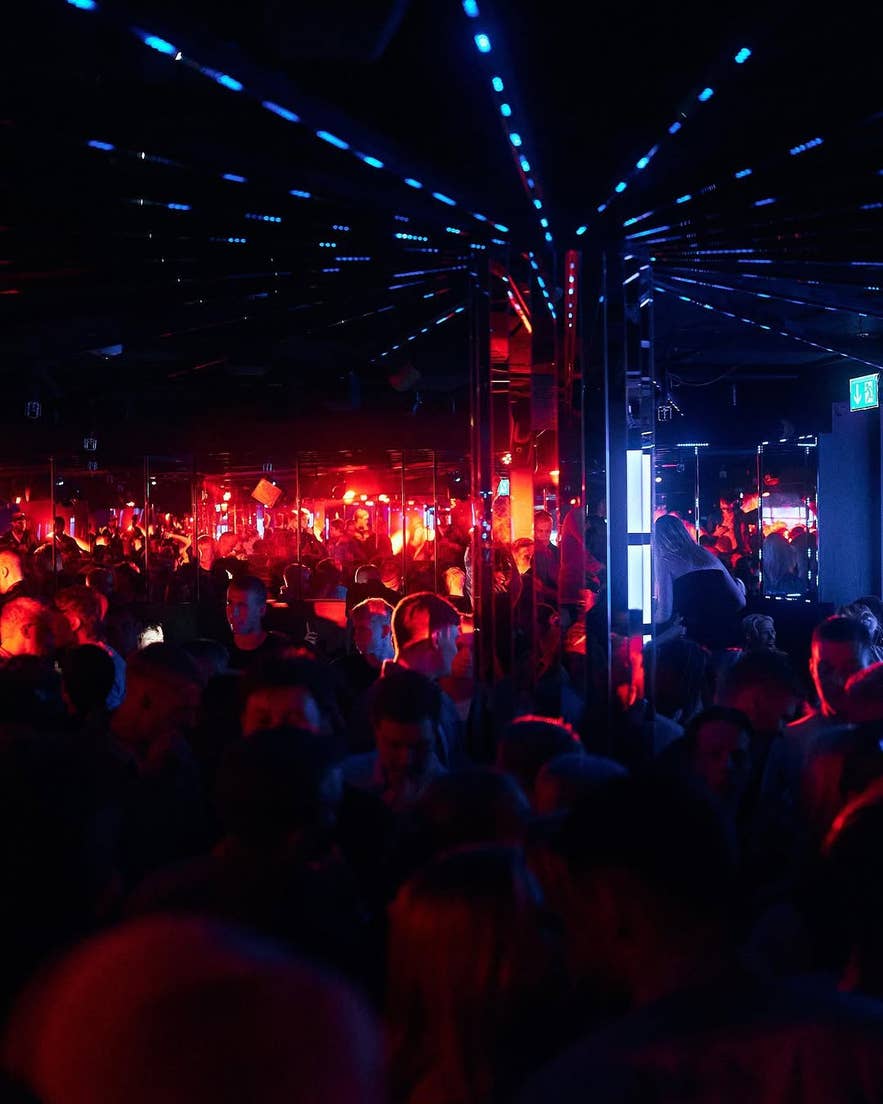 Volle dansvloer bij AUTO Nightclub in Reykjavik, met rode en blauwe sfeerverlichting.