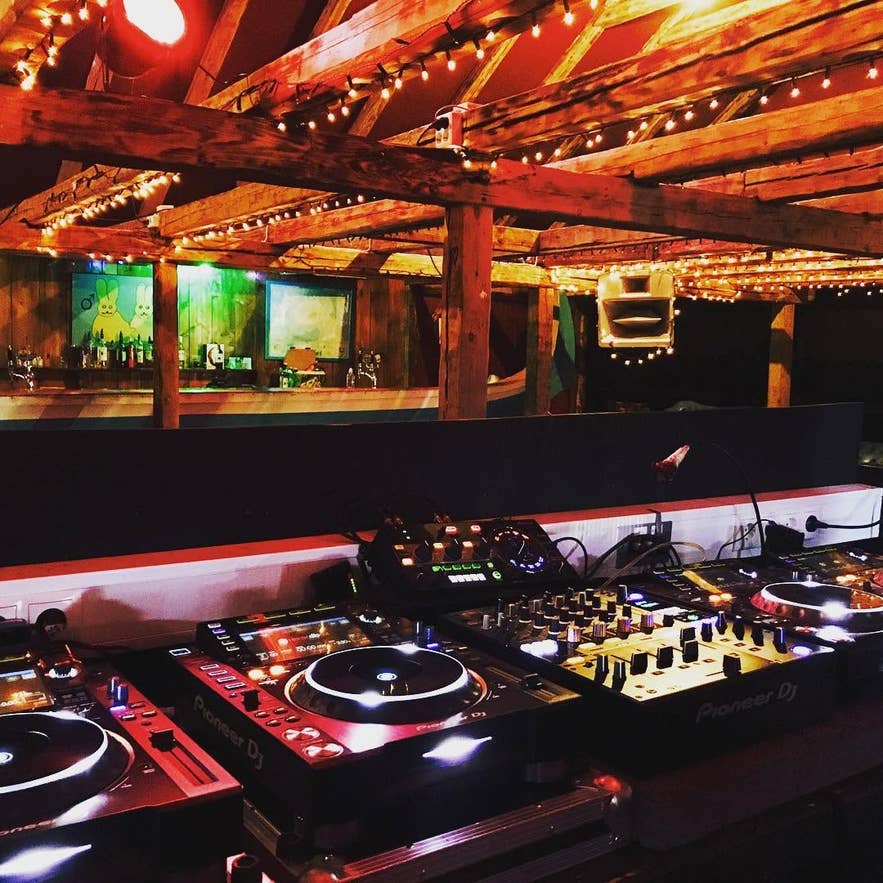 DJ-booth en zichtbaar houten balkenplafond op de dansvloer in de kelder van Paloma Club in Reykjavik.