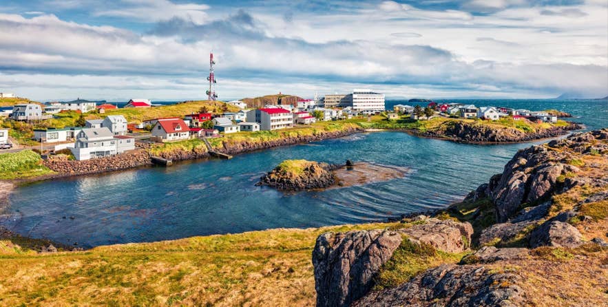 Coastal view of Stykkisholmur with colorful houses, rocky shoreline, and a calm harbor on the Snaefellsnes Peninsula