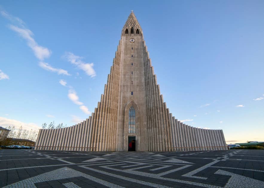 Hallgrímskirkja Church in Reykjavík under a bright sunny sky, viewed from the front with its distinctive tower rising above the city.