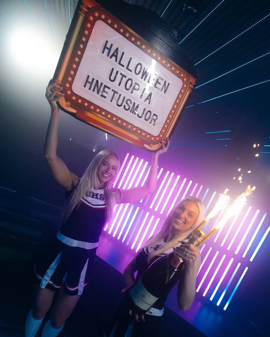 Halloweenavond in Utopia Nightclub in Reykjavik, met neonverlichting, sterretjes en een lichtbord waarop het evenement wordt aangekondigd.