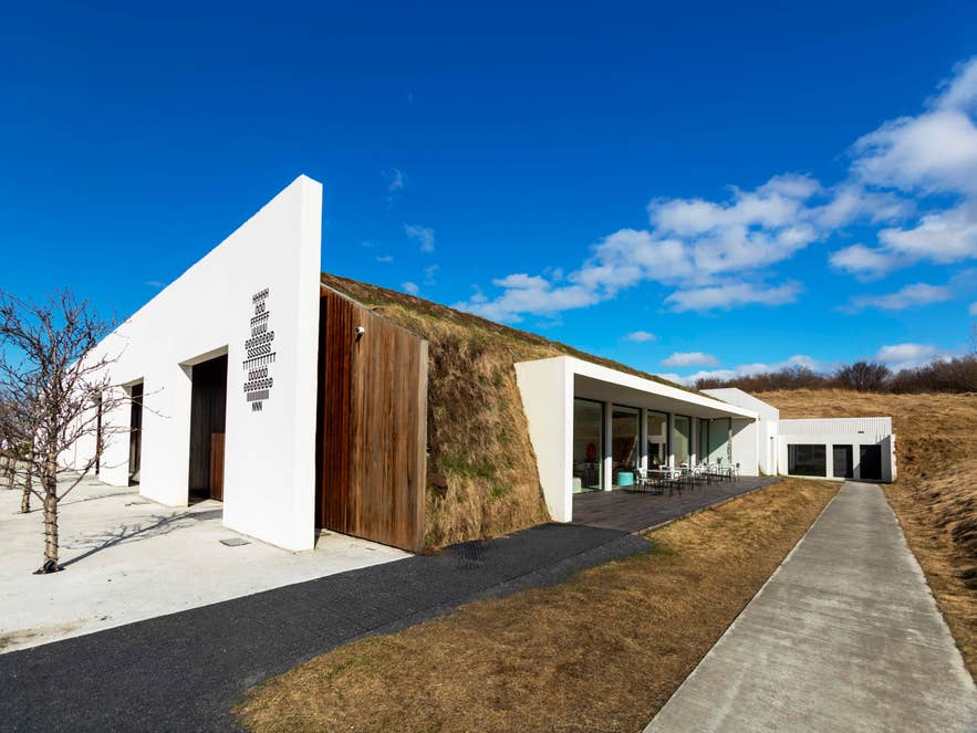 Exterior of Hofudstodin art and culture center in Reykjavik, with a turf-roofed white building.