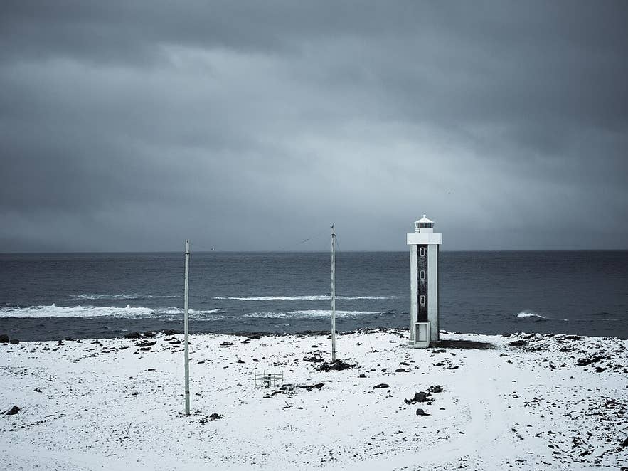 Streitisviti Lighthouse standing on the snowy Streiti coastline in East Iceland during winter.