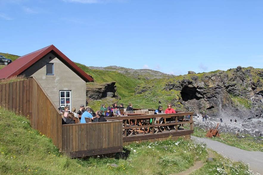 Fjoruhusid Cafe terrace overlooking the coastline and sea cliffs in Hellnar on the Snaefellsnes Peninsula, Iceland