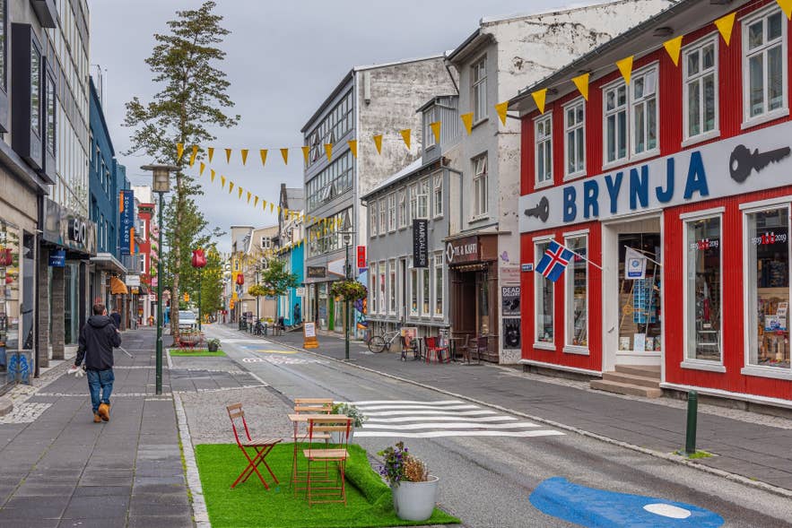 Pedestrians walking the colorful storefronts of Laugavegur Street in Reykjavik.