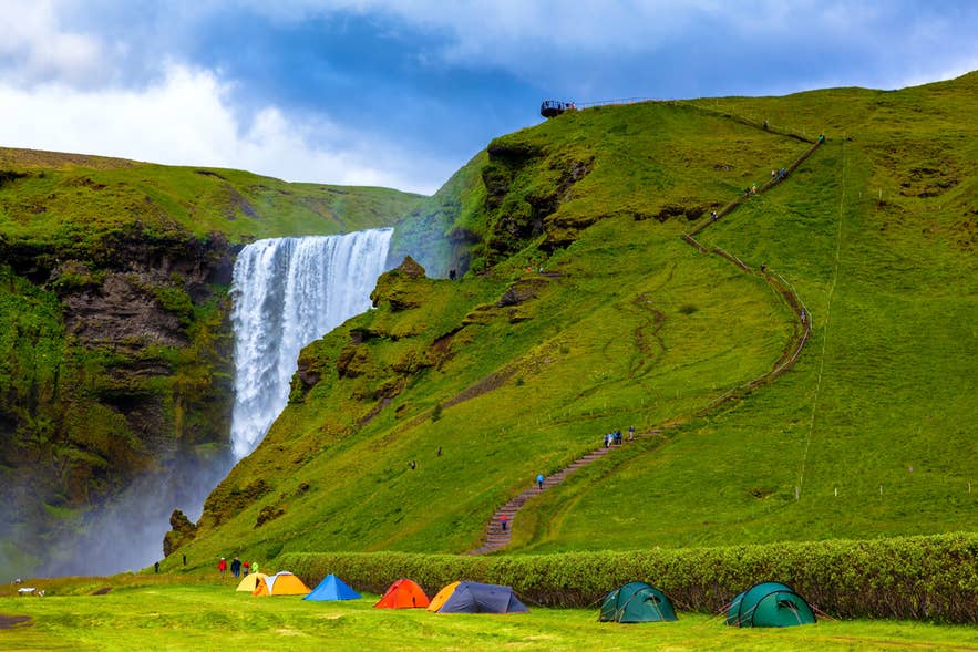 Some colorful tourist tents near the grand waterfall Skogafoss.