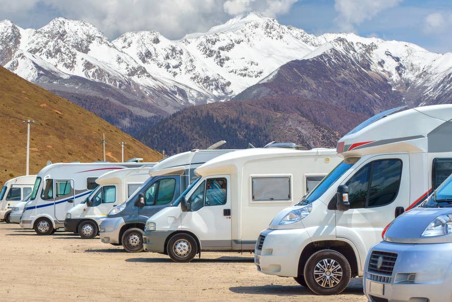 Close up motorhomes parked in a row on background snow mountain nature landscape.