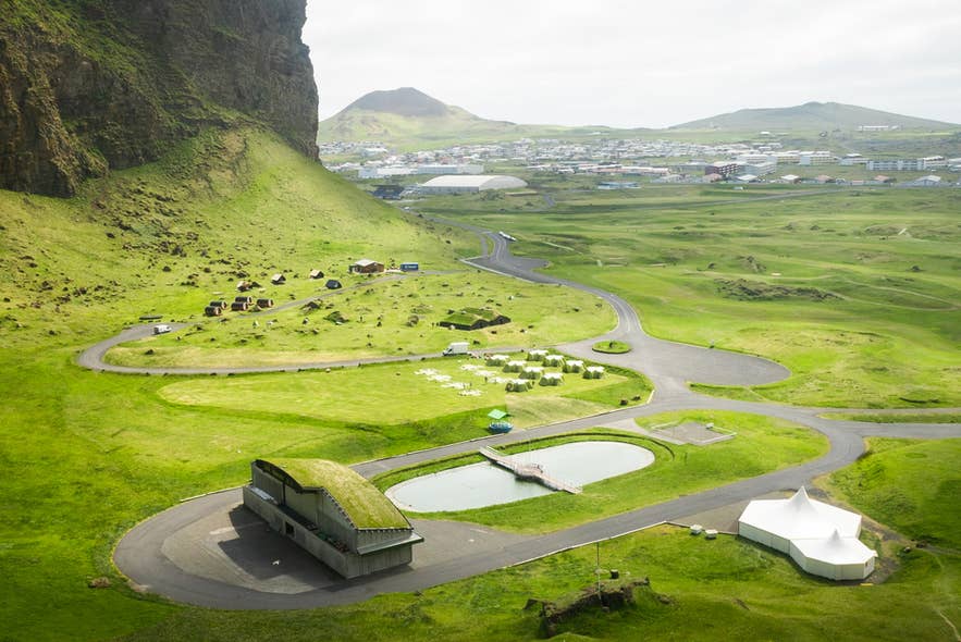 High angle shot of Herjolfsdalur, an iconic campsite in Iceland, covered with bright vivid green grass and moss.