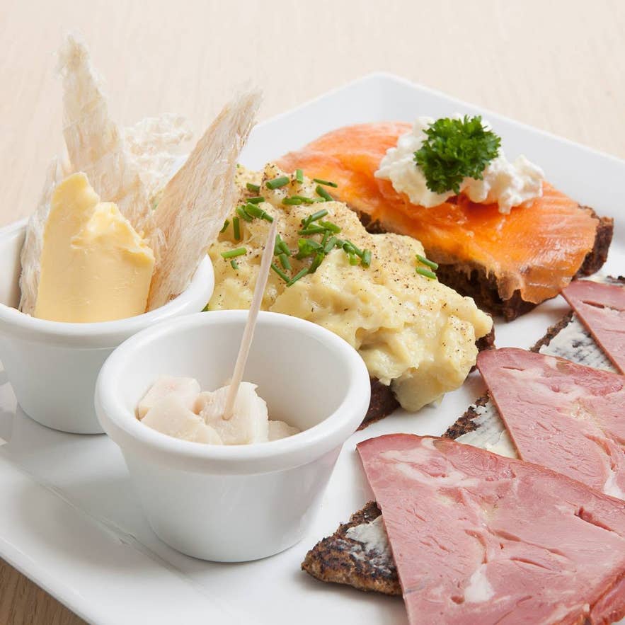 Icelandic plate at Cafe Loki with fermented shark, dried fish with butter, smoked lamb, and salmon on rye. Icelandic plate at Cafe Loki with fermented shark, dried fish with butter, smoked lamb, and salmon on rye.