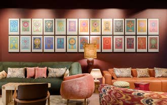 Cozy nook with a gallery wall of framed art beside a bed at Skald Hotel Akureyri in North Iceland.