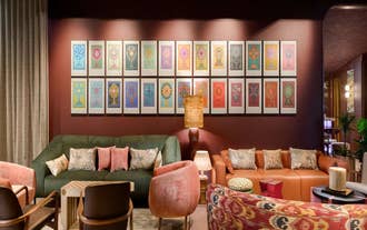 Cozy nook with a gallery wall of framed art beside a bed at Skald Hotel Akureyri in North Iceland.