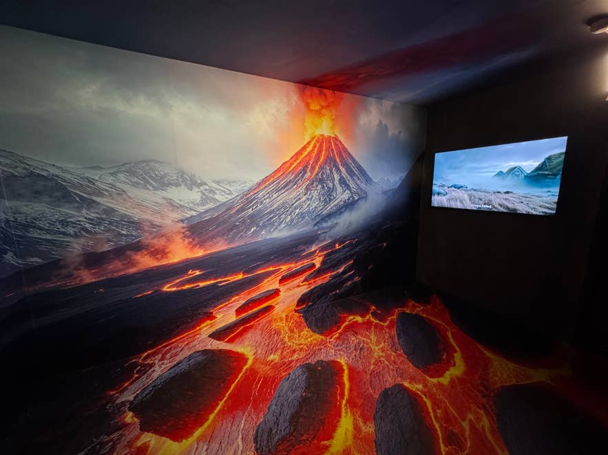 Volcano room at The Story of Icelanders show in Reykjavik, with an erupting volcano and lava flows covering the walls and floor around a screen.