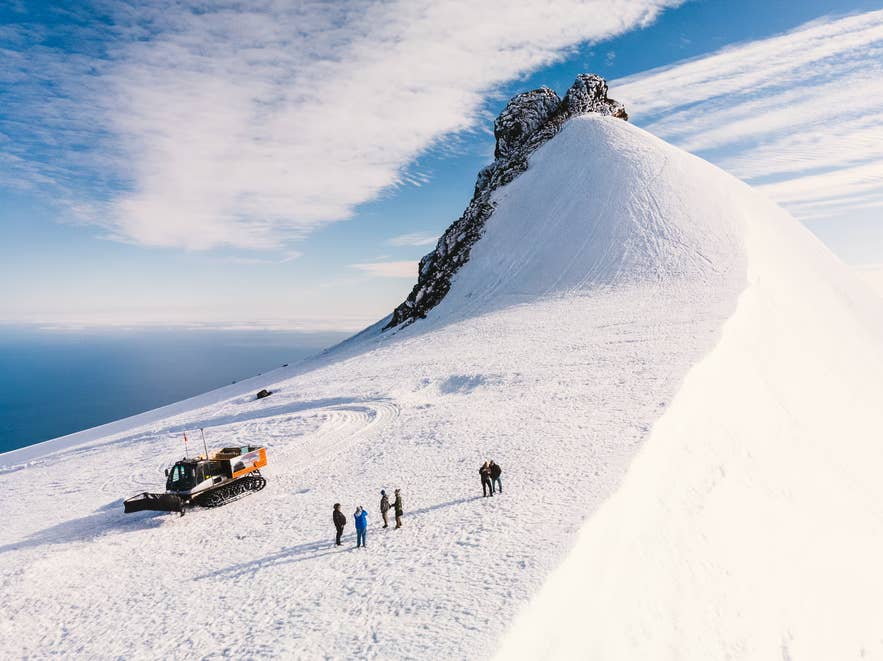Hikers and a snowcat near the rocky summit ridge of Snaefellsjokull Glacier. Hikers and a snowcat near the rocky summit ridge of Snaefellsjokull Glacier.