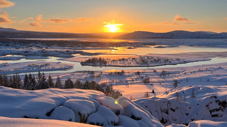 Winter solstice sunset over the snow-covered landscape and frozen waterways of Thingvellir National Park.