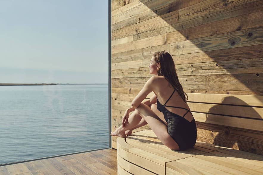 Woman enjoying the sauna with a view at the Sky Lagoon in Iceland.