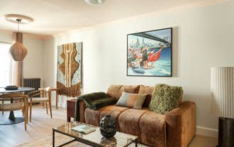 Living room with a dark sofa and framed abstract art in a self-catering apartment of Laugavegur's The Collector´s House by Muse.