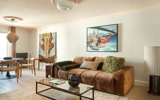Living room with a dark sofa and framed abstract art in a self-catering apartment of Laugavegur's The Collector´s House by Muse.
