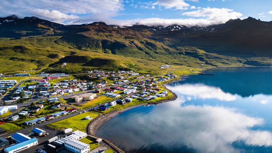 Aerial view of Grundarfjordur curving along its sheltered fjord, with mountains rising behind the town.