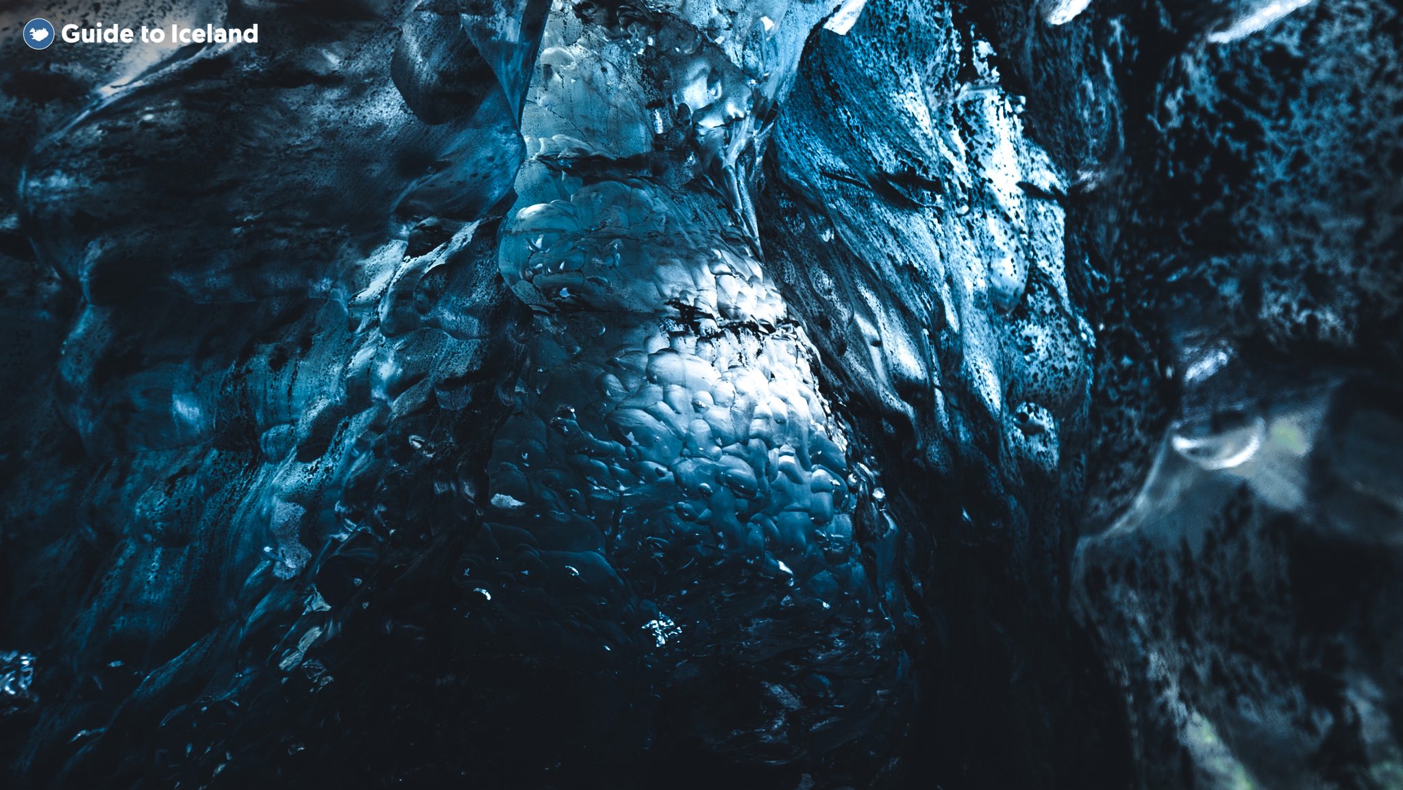 Light plays across the deep-blue, sculpted ice of a glacier cave in Vatnajökull, southeast Iceland.