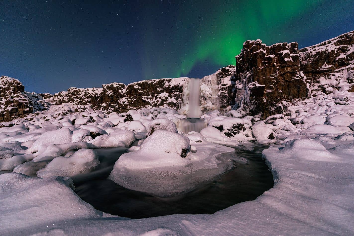 The church at Þingvellir and its houses reflect in still water at