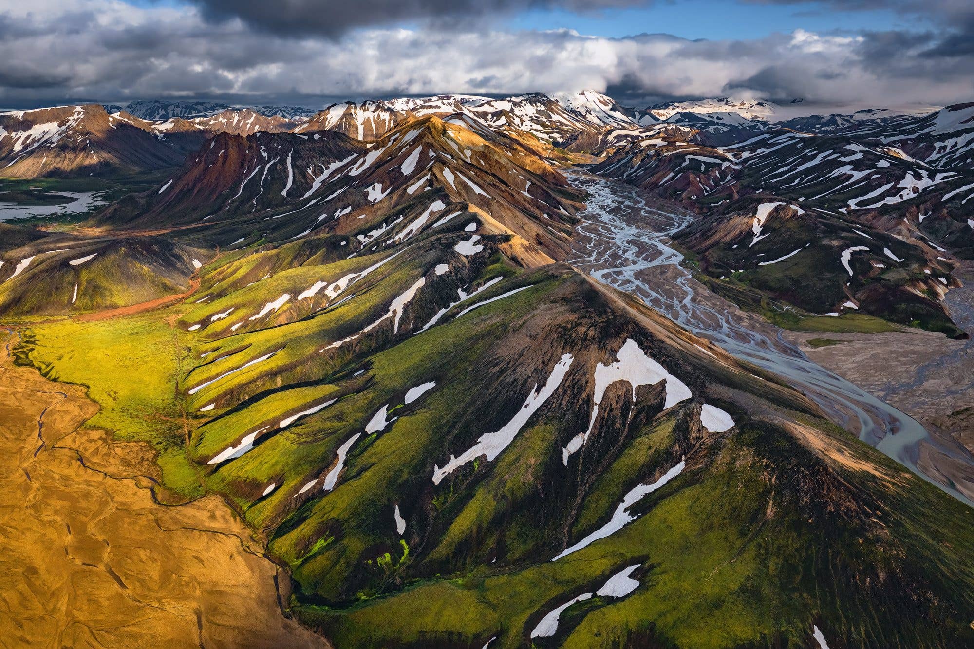 Snow-streaked rhyolite peaks and lava fields of Landmannalaugar spread out below in the Icelandic Highlands.