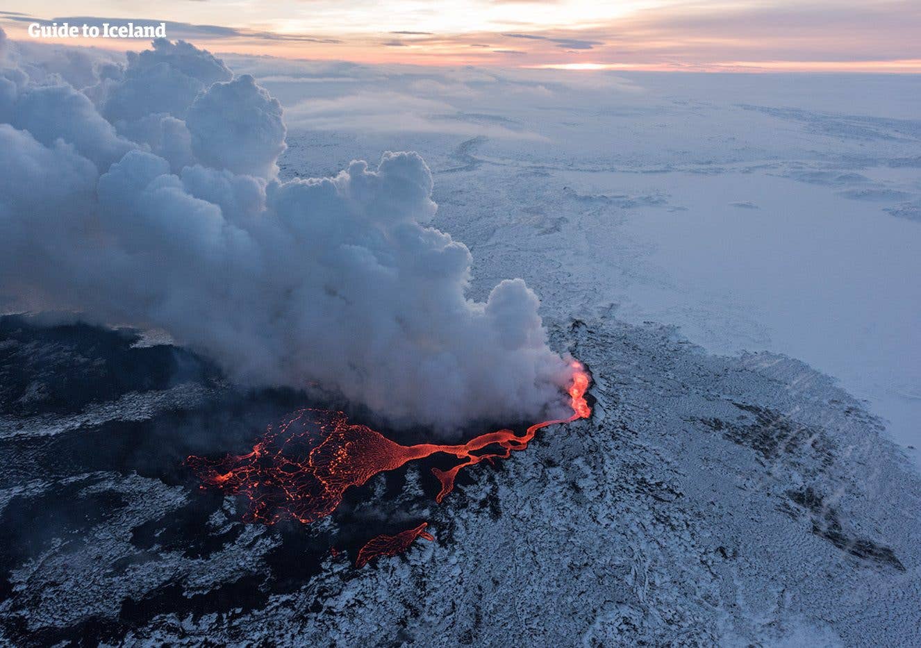Steam and lava burst from an erupting fissure surrounded by snow at Holuhraun in the Highlands of Iceland.