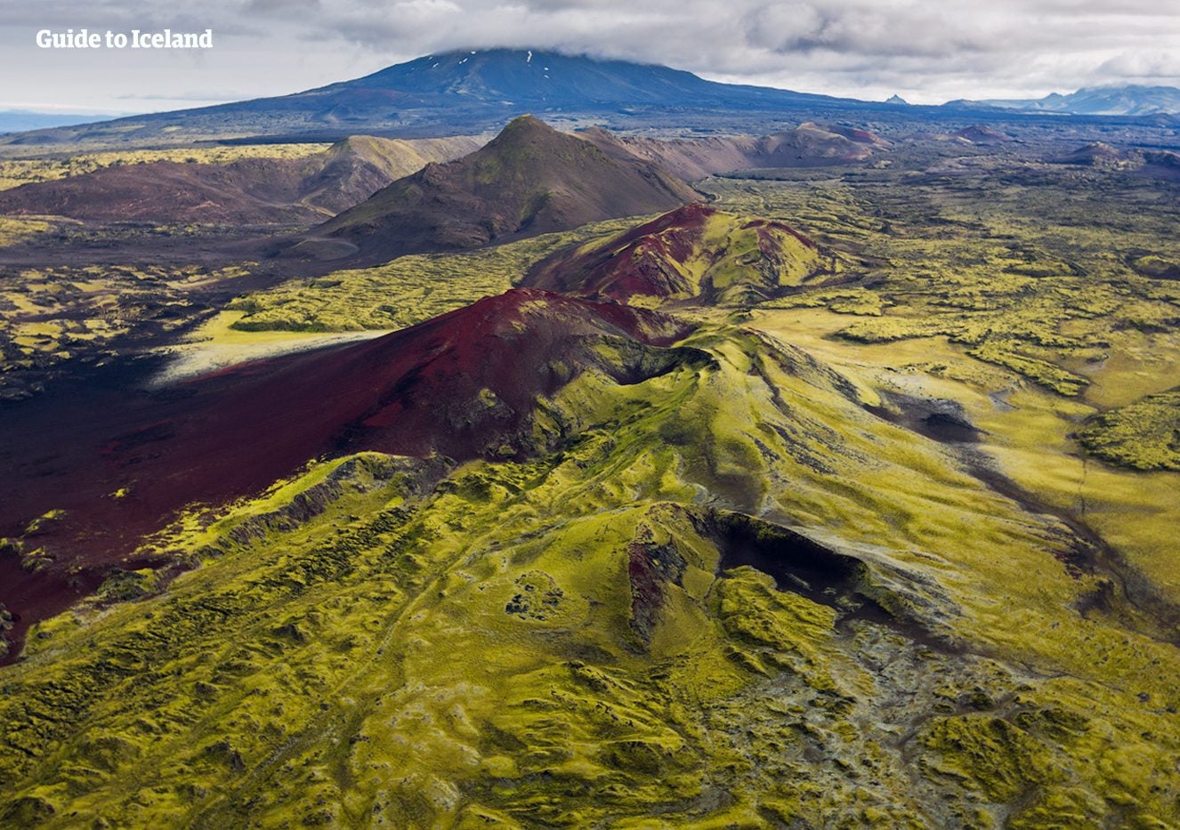 A green, moss-covered volcanic ridge and lava field stretch across the Icelandic Highlands.
