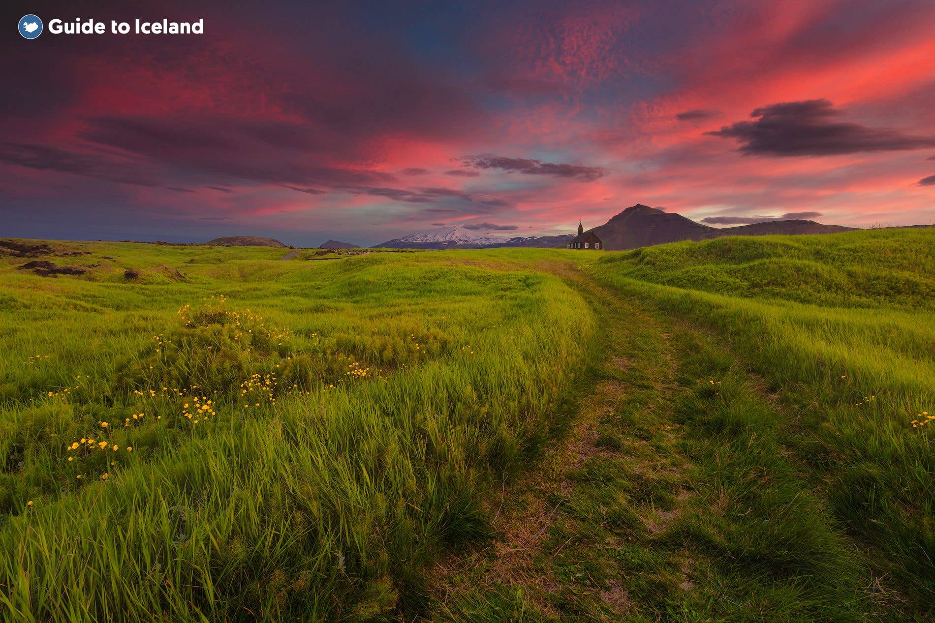 A fiery pink sunset lights the sky above the black Búðakirkja church on the Snæfellsnes Peninsula, West Iceland.