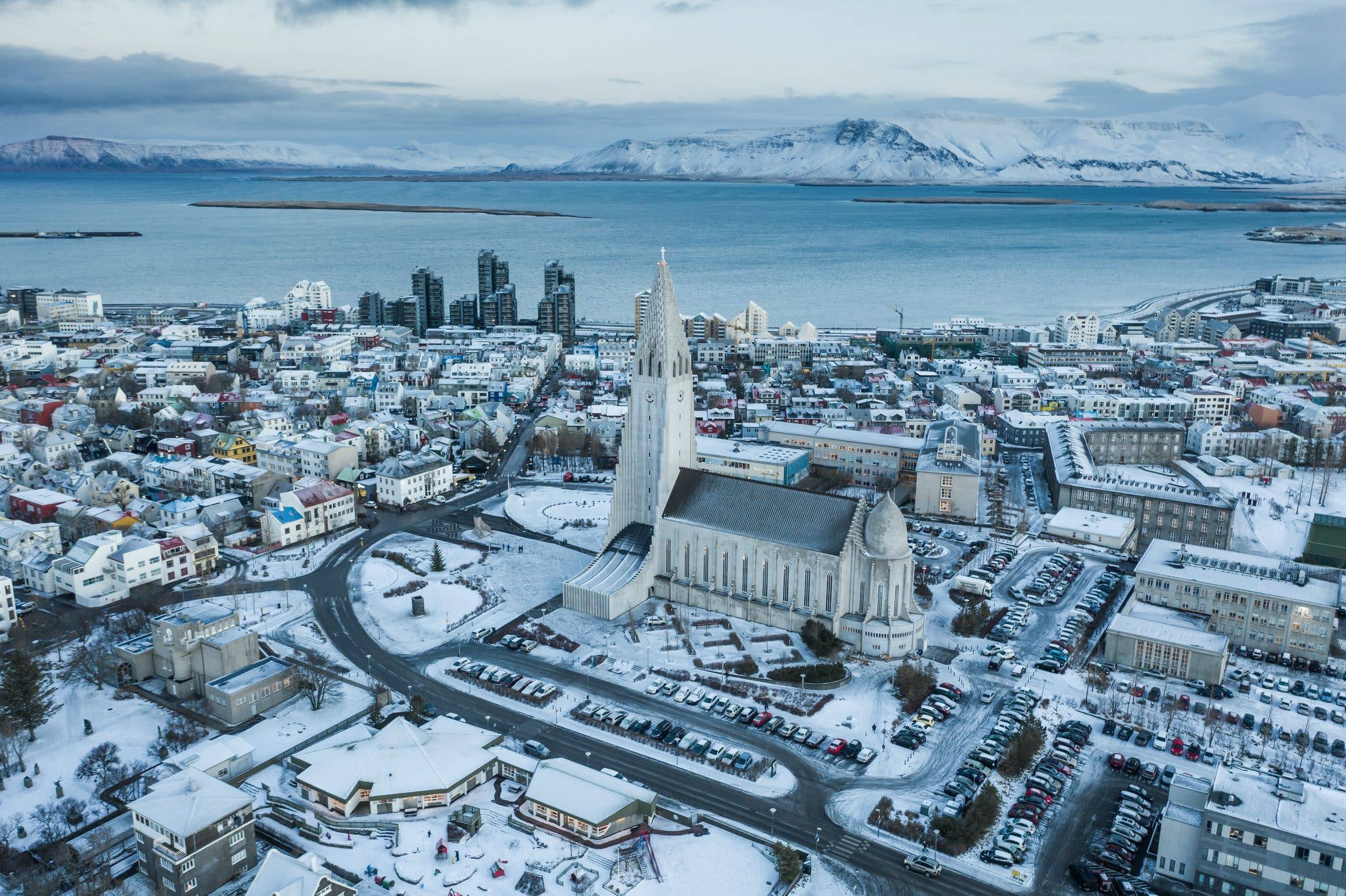 An aerial view of snow-covered Reykjavík with Hallgrímskirkja church and the sea beyond, Iceland.
