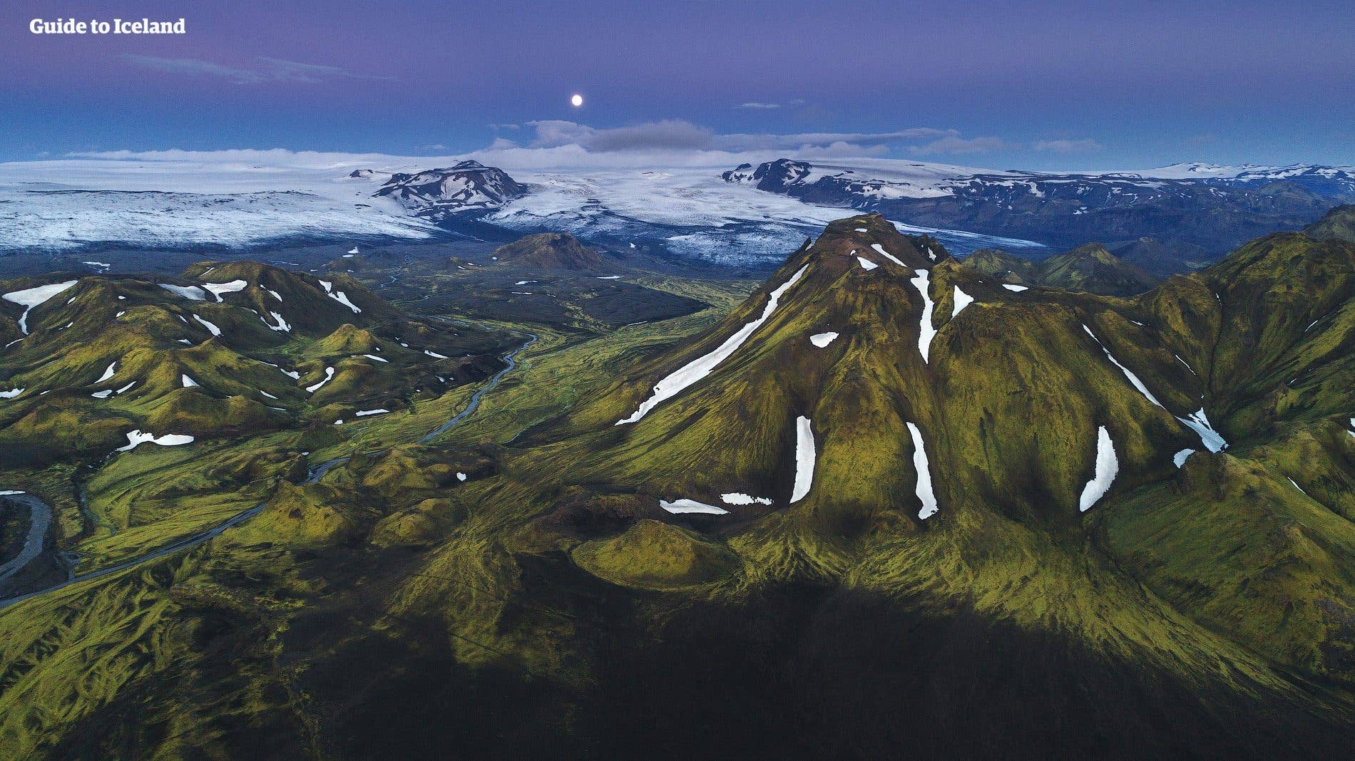 The Entujökull glacier tongue reaches down toward moss-green peaks in the Fjallabak Highlands of Iceland.