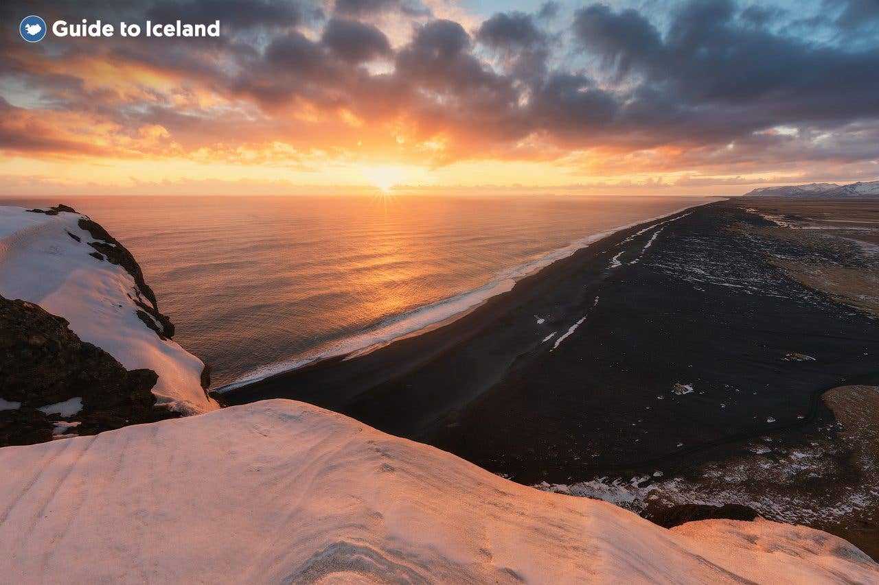 The winter sun rises over the black-sand coast at Dyrhólaey in South Iceland.