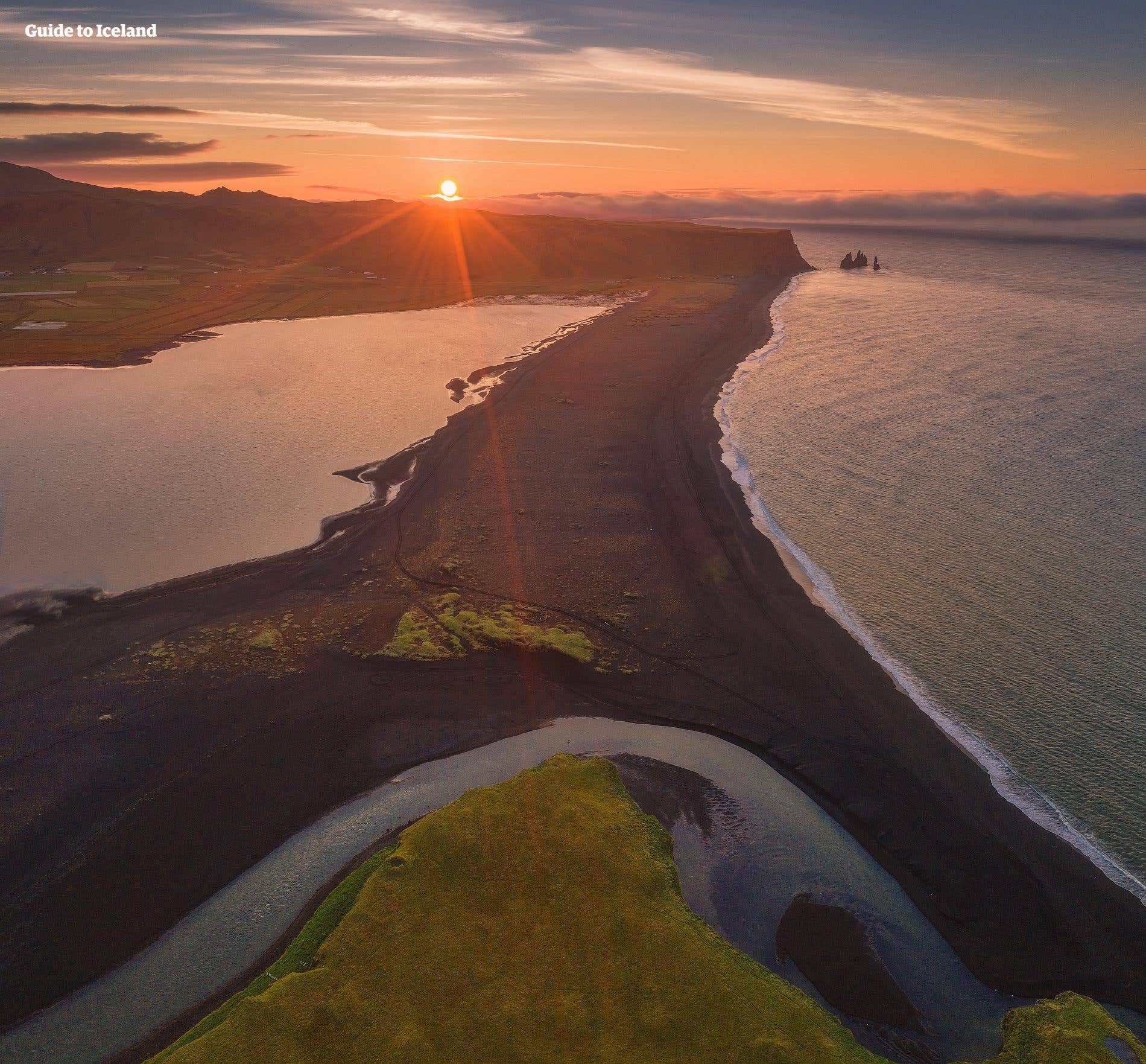 The midnight sun lingers over the black-sand beach and Reynisdrangar sea stacks near Vík on the south coast of Iceland.