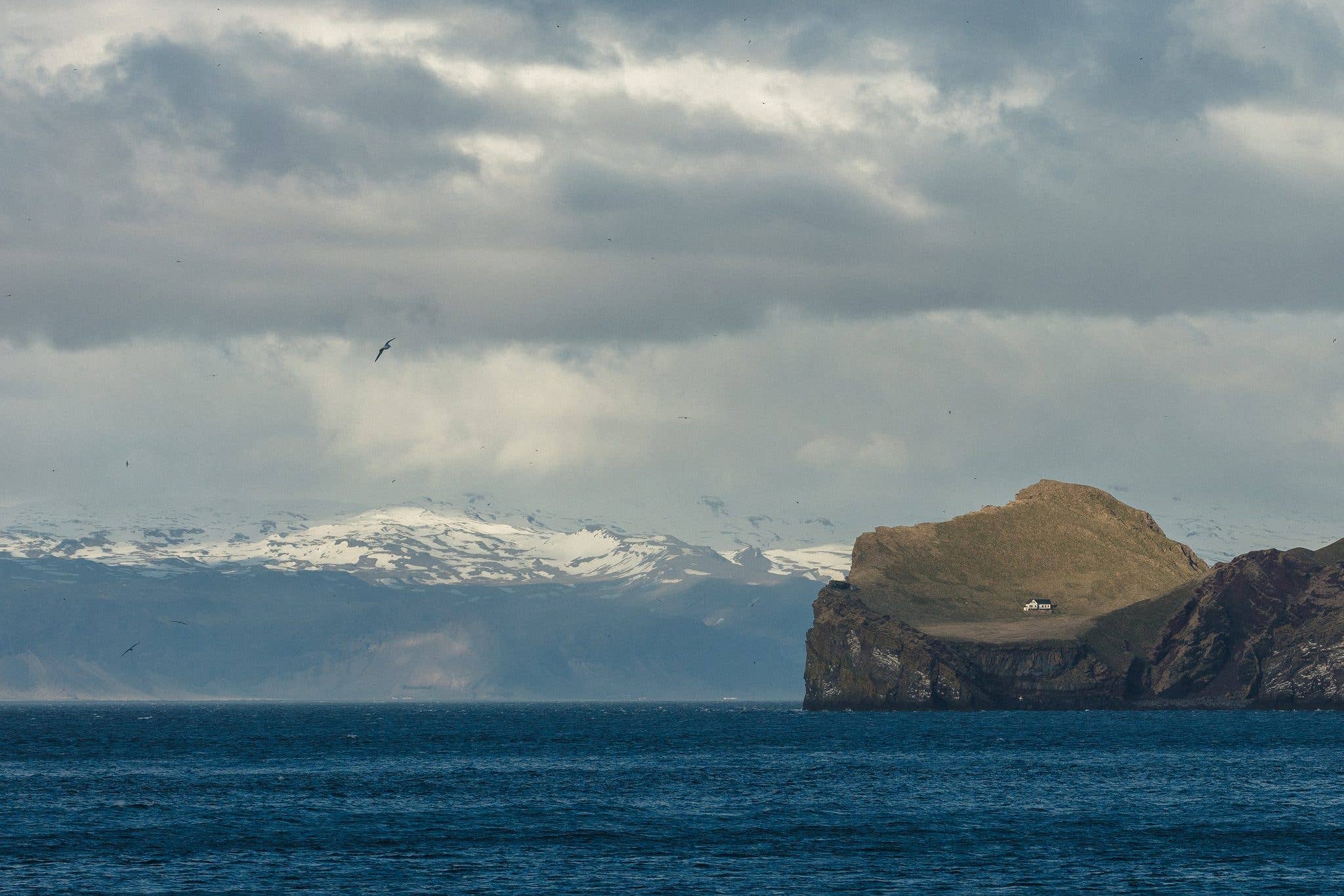 A lone house sits on the green island of Elliðaey in the Westman Islands off the south coast of Iceland.