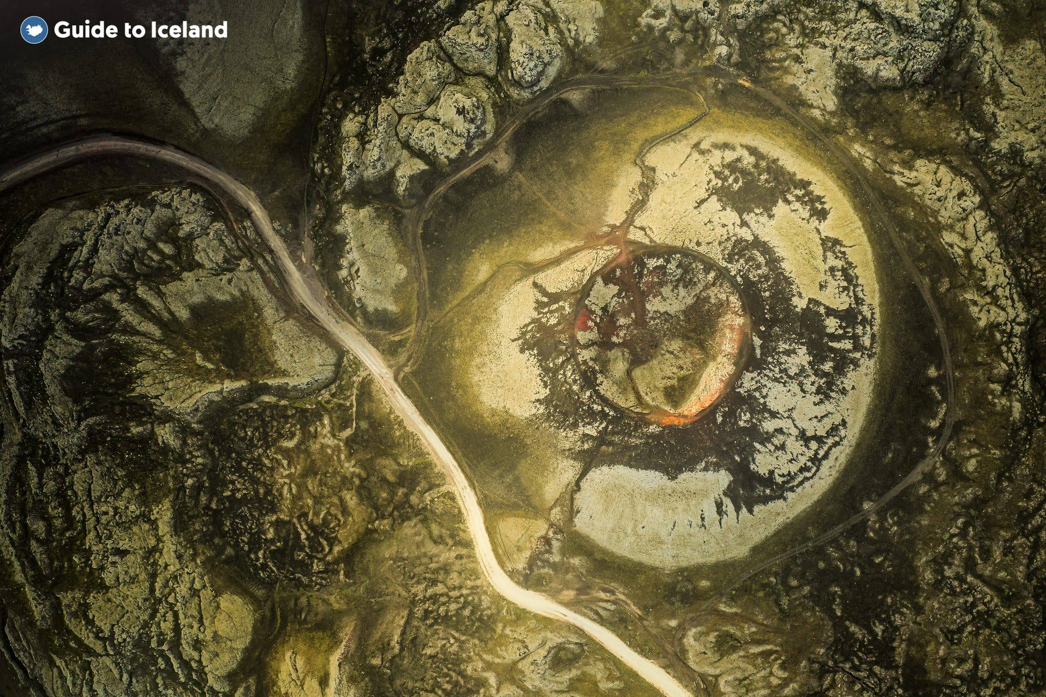An aerial view of the moss-covered Stútur crater with a path winding through the Landmannalaugar area, Iceland.
