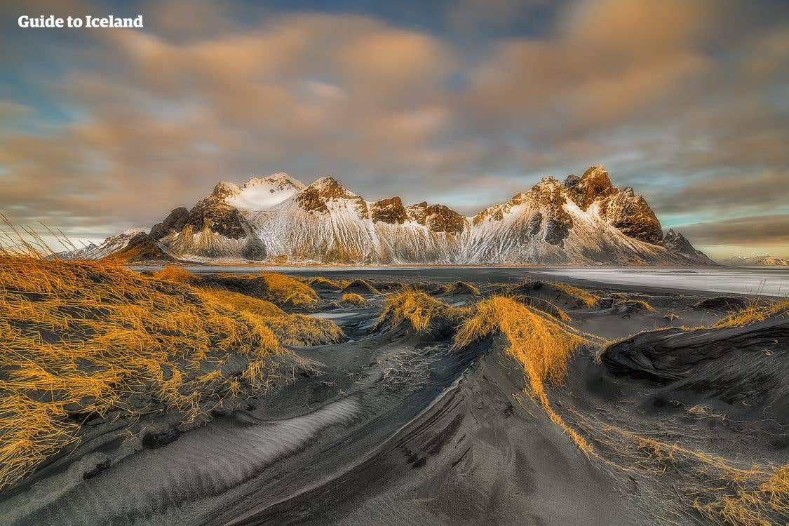 Golden grass and black dunes lead to the snow-dusted peaks of Vestrahorn at Stokksnes, southeast Iceland.