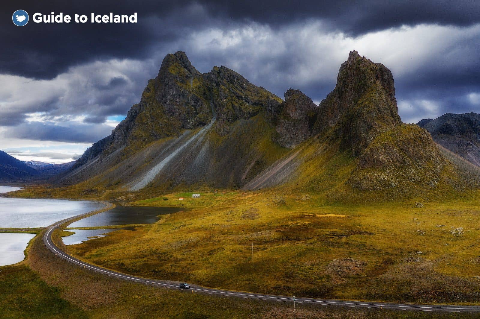A road curves below the sharp Eystrahorn mountains amid autumn colours in southeast Iceland.
