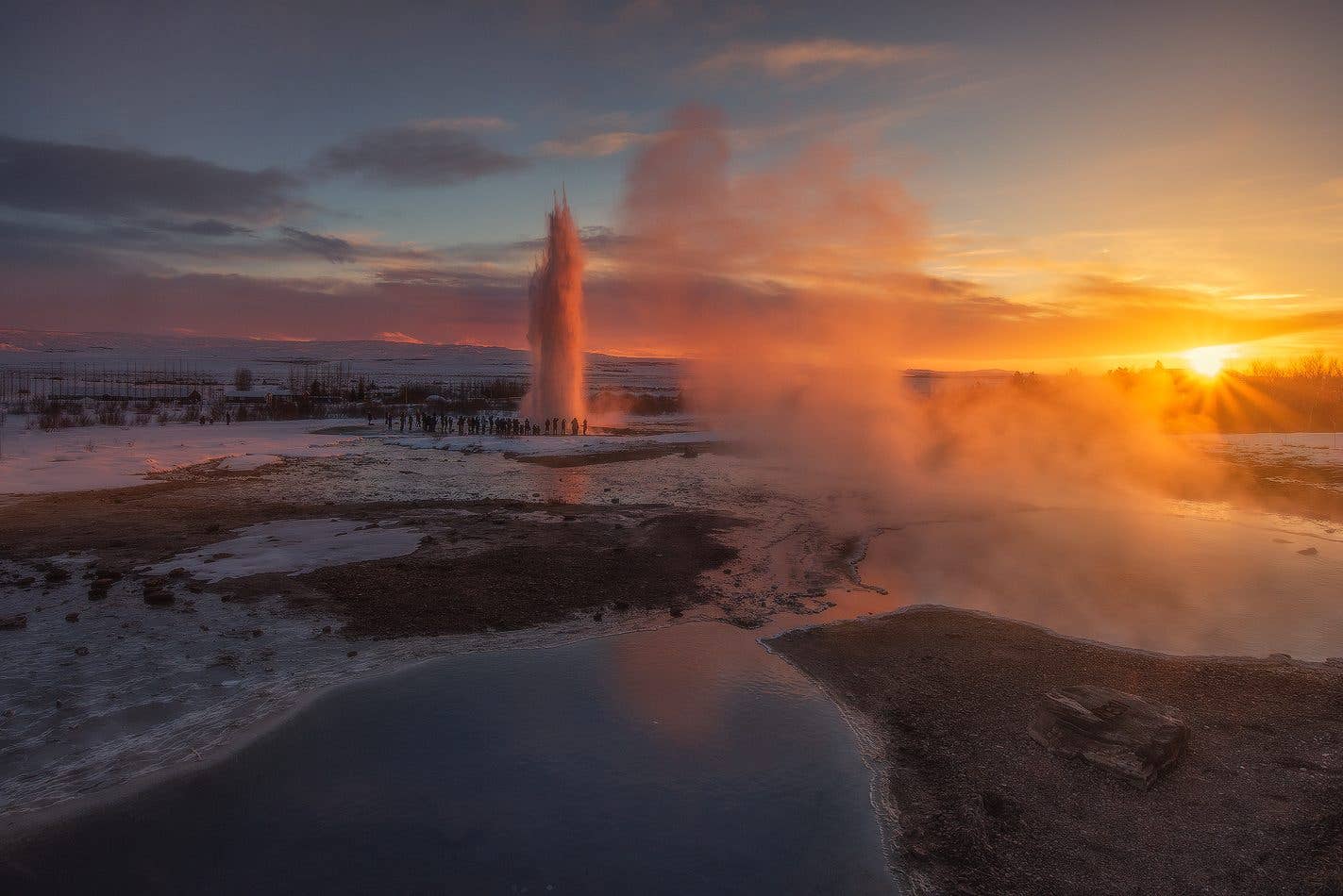 The Strokkur geyser erupts at sunset in the Geysir geothermal area on the Golden Circle, Iceland.