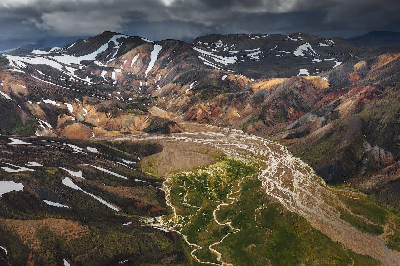 Colourful rhyolite mountains and a braided river fill the Fjallabak Highlands of Iceland.