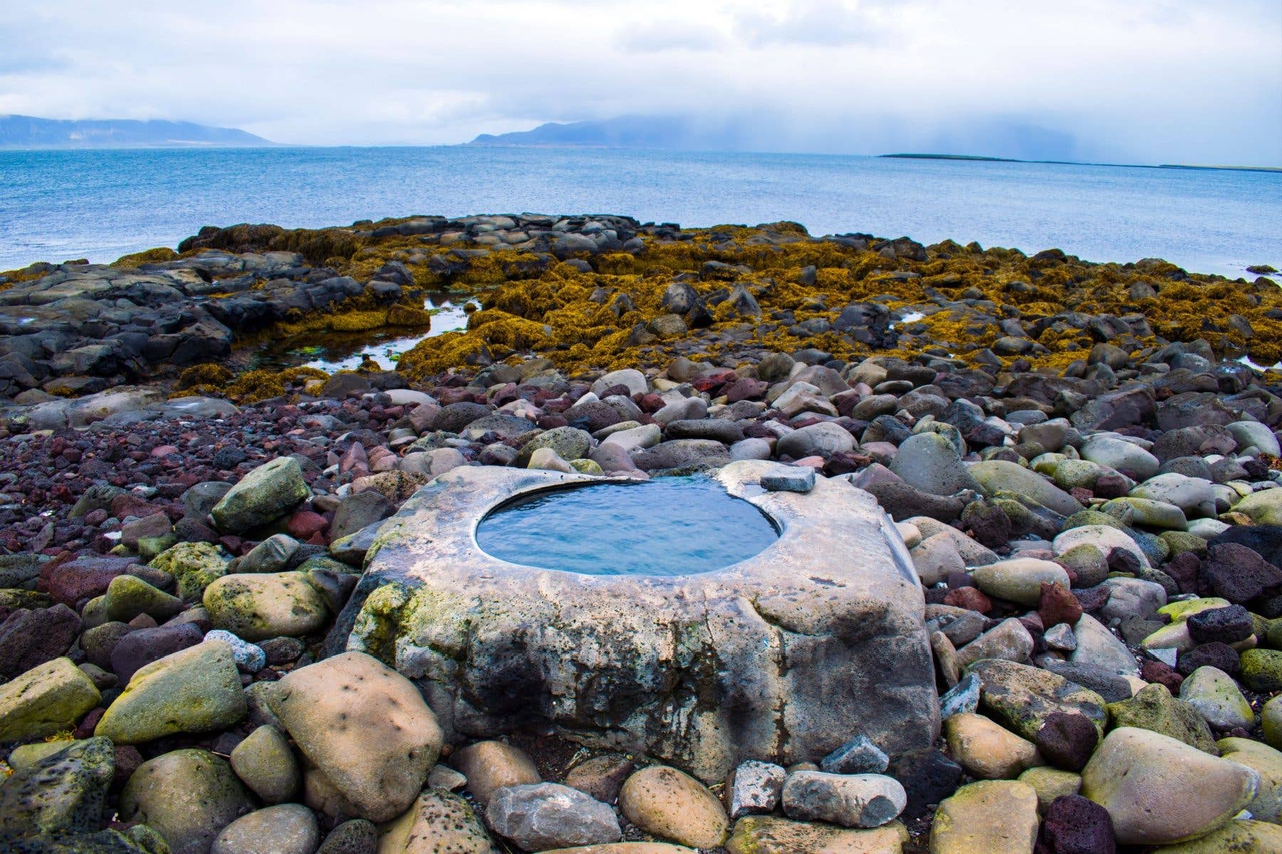 The Kvika foot bath sits among the rocks of the Seltjarnarnes reserve on the edge of Reykjavík, Iceland.