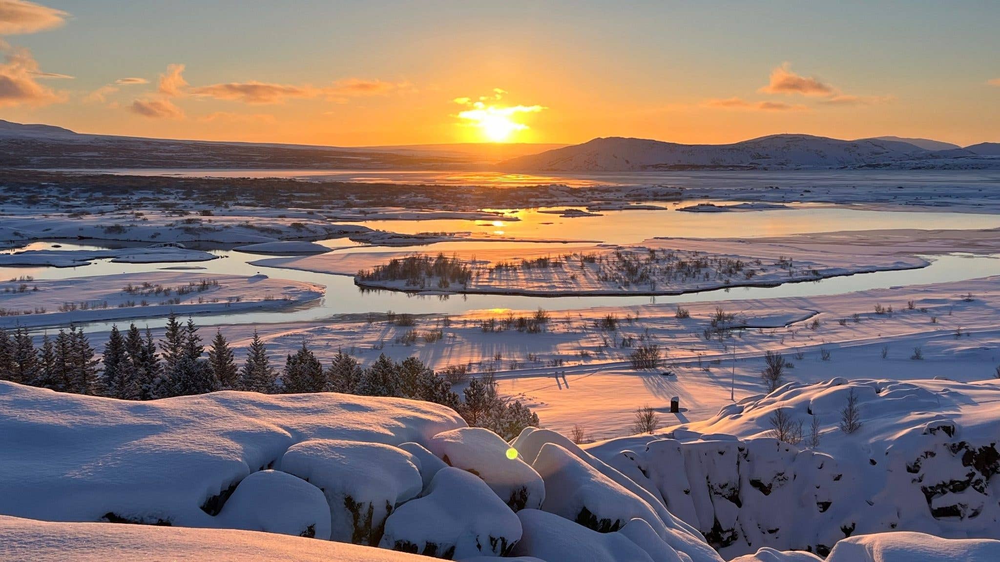 A winter sunset colours the snow-covered plains of Þingvellir National Park in Iceland.